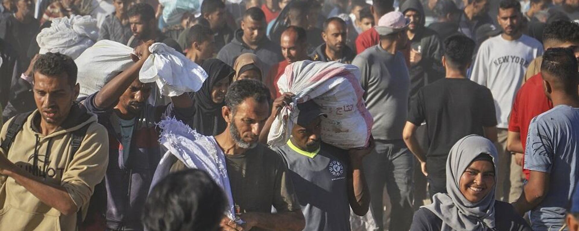 فلسطينيون يحملون صناديق وأكياسا تحتوي على مساعدات غذائية وإنسانية قدمتها مؤسسة غزة، المدعومة من أمريكا ووافقت عليها إسرائيل، في رفح جنوب قطاع غزة، 29 مايو/ أيار 2025 - سبوتنيك عربي, 1920, 12.06.2025