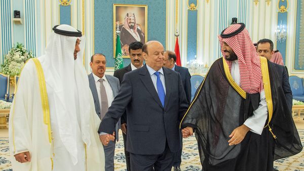 الرئيس اليمني عبد ربه منصور هادي ماسكا بيده اليمنى ولي عهد أبو ظبي الشيخ محمد بن زايد آل نهيان وبيسراه ولي العهد السعودي الأمير محمد بن سلمان أثناء التوقيع على اتفاق الرياض في السعودية - سبوتنيك عربي
